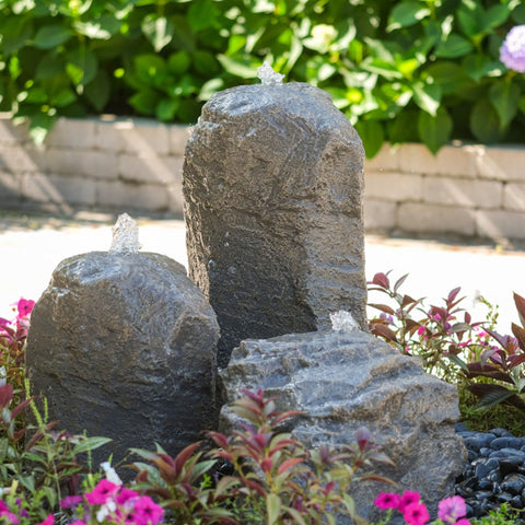 Cascade Mini-Mountain Spring Triple Stone Outdoor Fountain Surrounded By Plants And Flowers