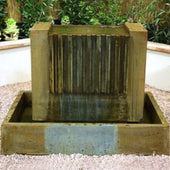 Cascading Falls Style Outdoor Water Fountain With Plants In The Background