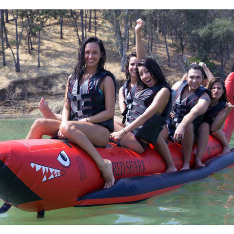 Elite Class 6 Person Red Shark Banana Boat With A Group Having Fun And Excited For A Ride With A Forested Hillside in the Background