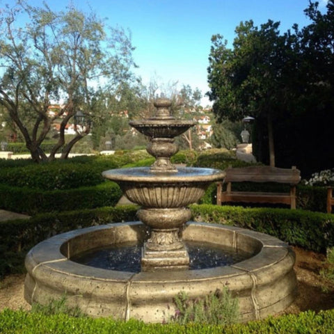 Fiore Stone Formal Garden Fountain with Fiore Pond Surrounded By Grass With Trees In The Background