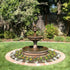 Thumbnail for Giannini Garden Fleur De Lis Pond Fountain At Lush Backyard Garden With Fence And Trees In The Background