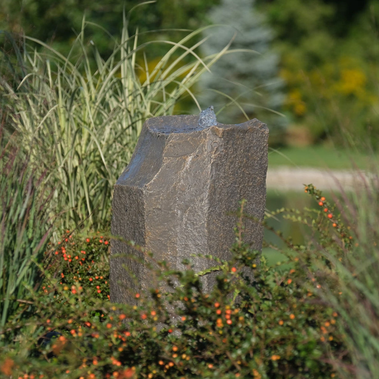 Hollow Springs Garden Rock Fountain Surrounded By Ornamental Grass