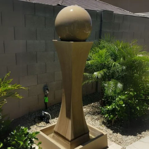 I With Ball Garden Water Fountain By Gist With Palm Plants And Gray Wall In The Background