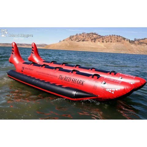 Island Hopper 10 Person Red Shark Banana Boat Resting In Calm Water With Mountain View