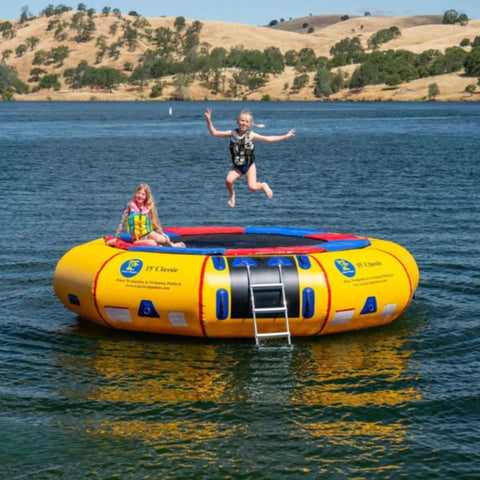Island Hopper 15 Classic Water Trampoline One Kid Jumping While Other Girl Setting With Mountain View