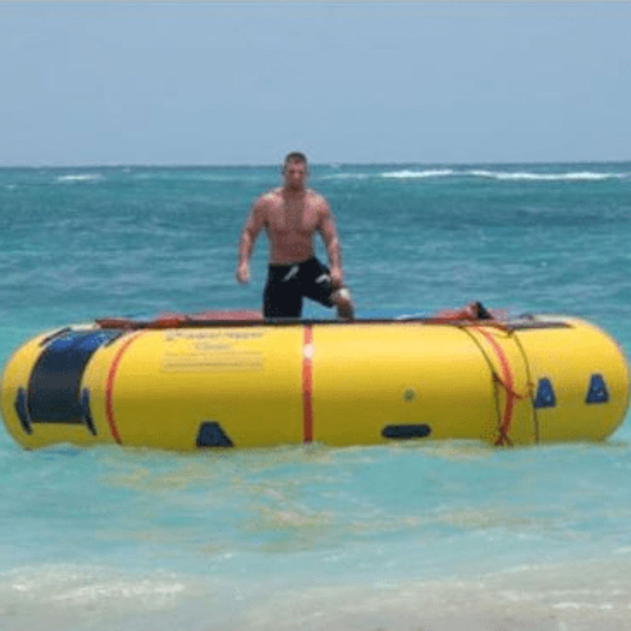 Island Hopper 15 Classic Water Trampoline With A Man Standing In Shallow Ocean Water