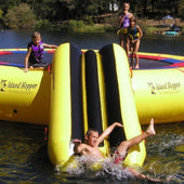 Island Hopper Bounce N Slide Attachment Boy Sliding Into Water With Three Children Watching On Lake