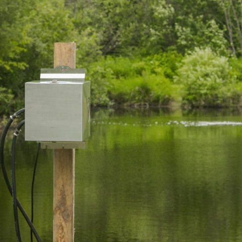 Kasco Small Pond Aeration System Installed On A Wooden Support Post With A Calm Water And Green Landscape
