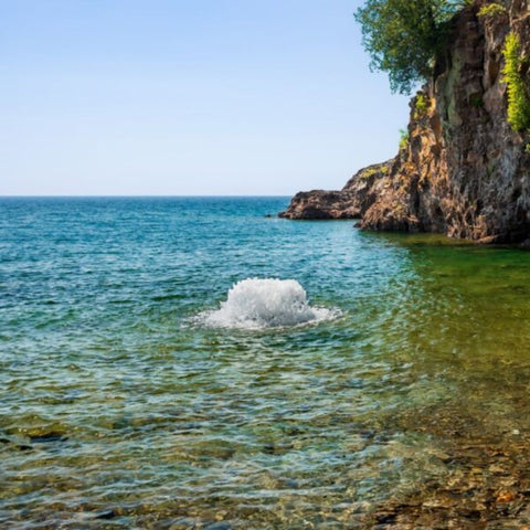 Kasco Surface Aerator On The Water In Shallow Water With Rocks In The Background