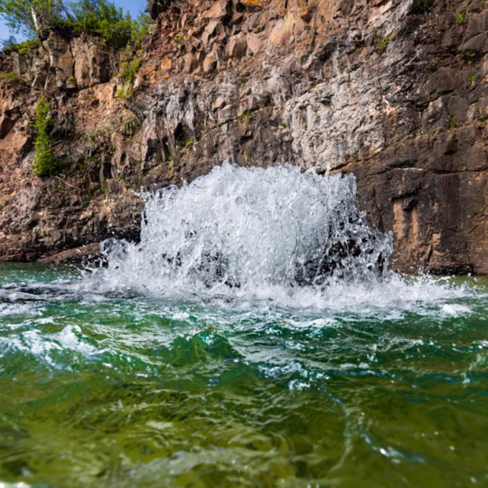 Kasco Surface Aerator On The Water With A Cliff Face In The Background