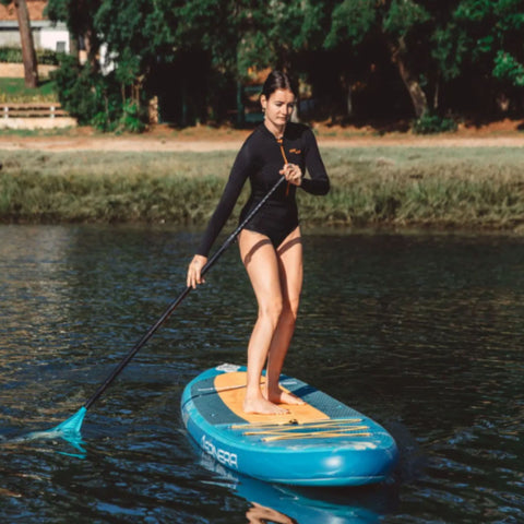 Lets Paddle 10.10 Paddle Board With a Girl Paddling Through Calm Water
