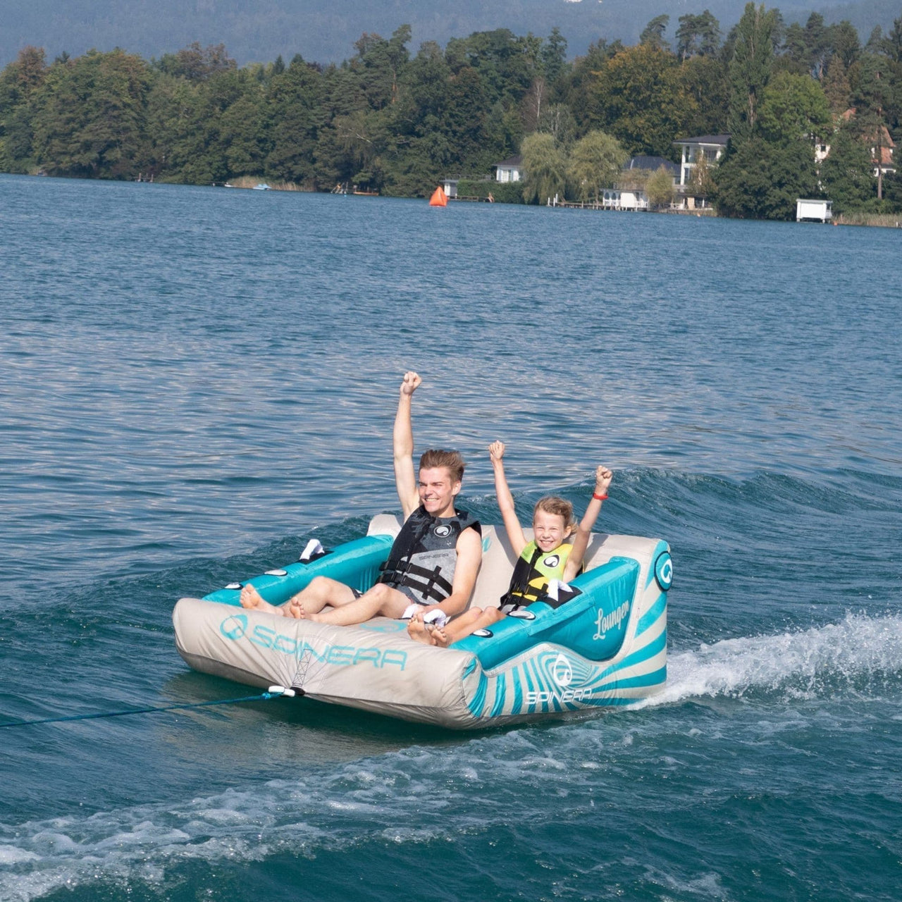 Lounger 2 Towable With Two Boys Raising Hands on Water Ride
