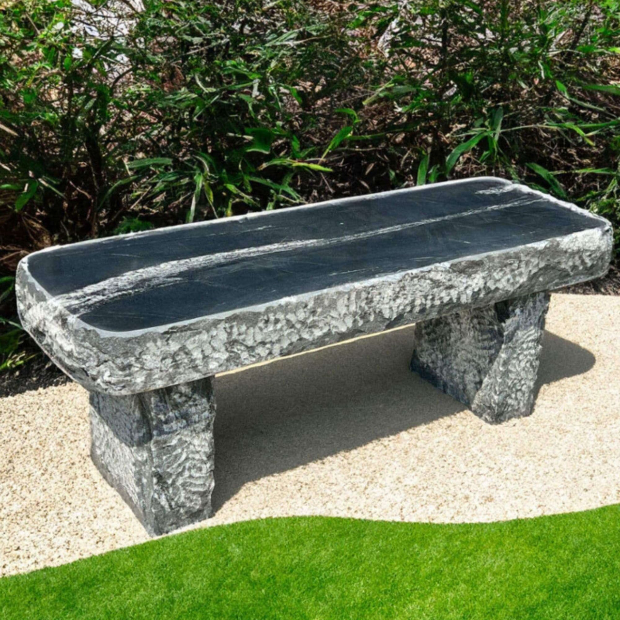Mountain Wave Granite 48 Garden Bench Placed On A Beige Gravel With Curved Green Lawn And Garden Bushes