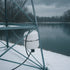 OWS Freeze Control Tank Mounted On Metal Tower Beside Snow-Covered Pond