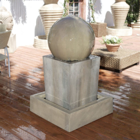 Obtuse With Ball Garden Water Fountain By Gist With Planters And Buddha Heads In The Background