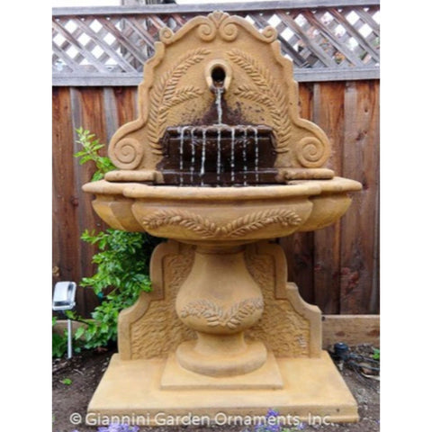 Olive Grove Wall Fountain With Wooden Fence In The Background