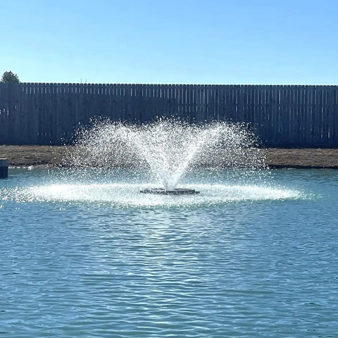 Outdoor Water Solutions 1/2 HP Aerify Electric Pond Aerator Fountain On The Water With A Fence In The Background