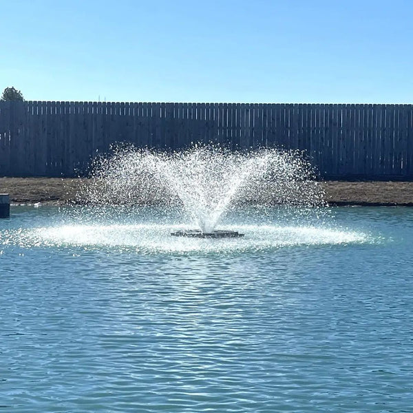 Outdoor Water Solutions 1/2 HP Aerify Electric Pond Aerator Fountain On The Water With A Fence In The Background