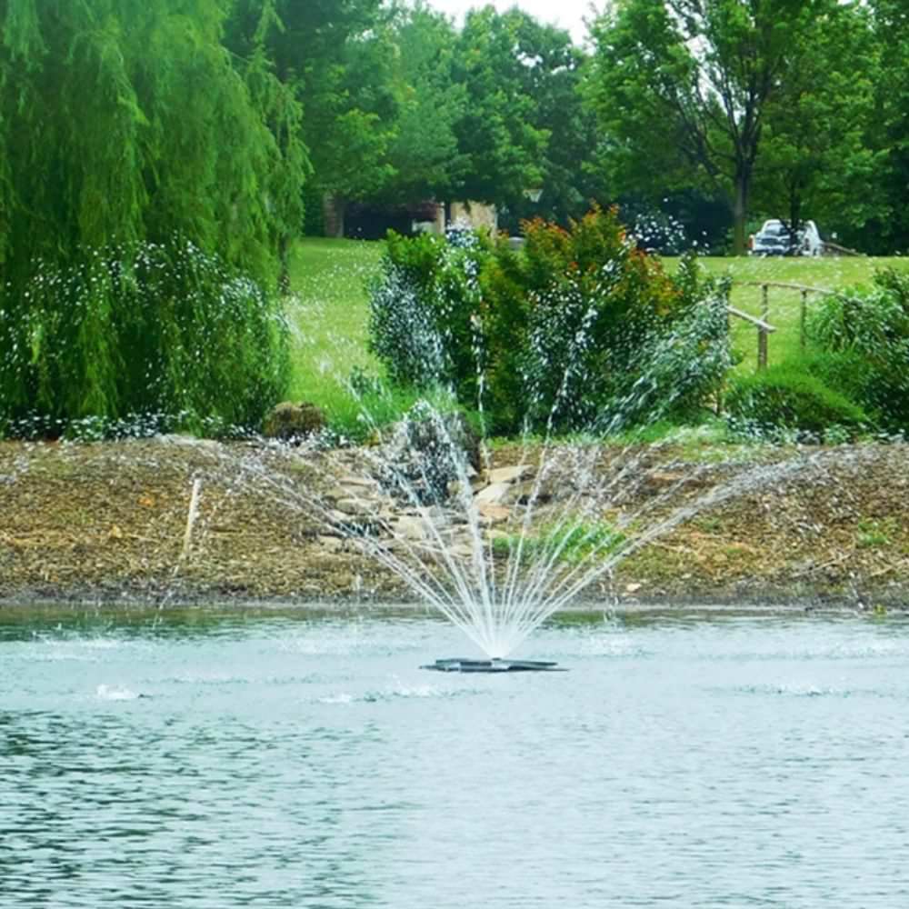 Outdoor Water Solutions EcoSeries Floating Pond Fountain ON The Water With Trees In The Background