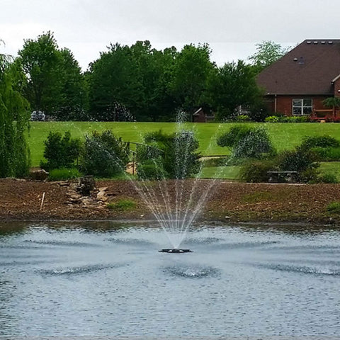 Outdoor Water Solutions EcoSeries Floating Pond Fountain On The Water With Trees In The Background