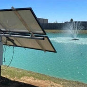 Outdoor Water Solutions Palatial Display Solar Pond Fountain On The Water With A Fence & A Building In The Background