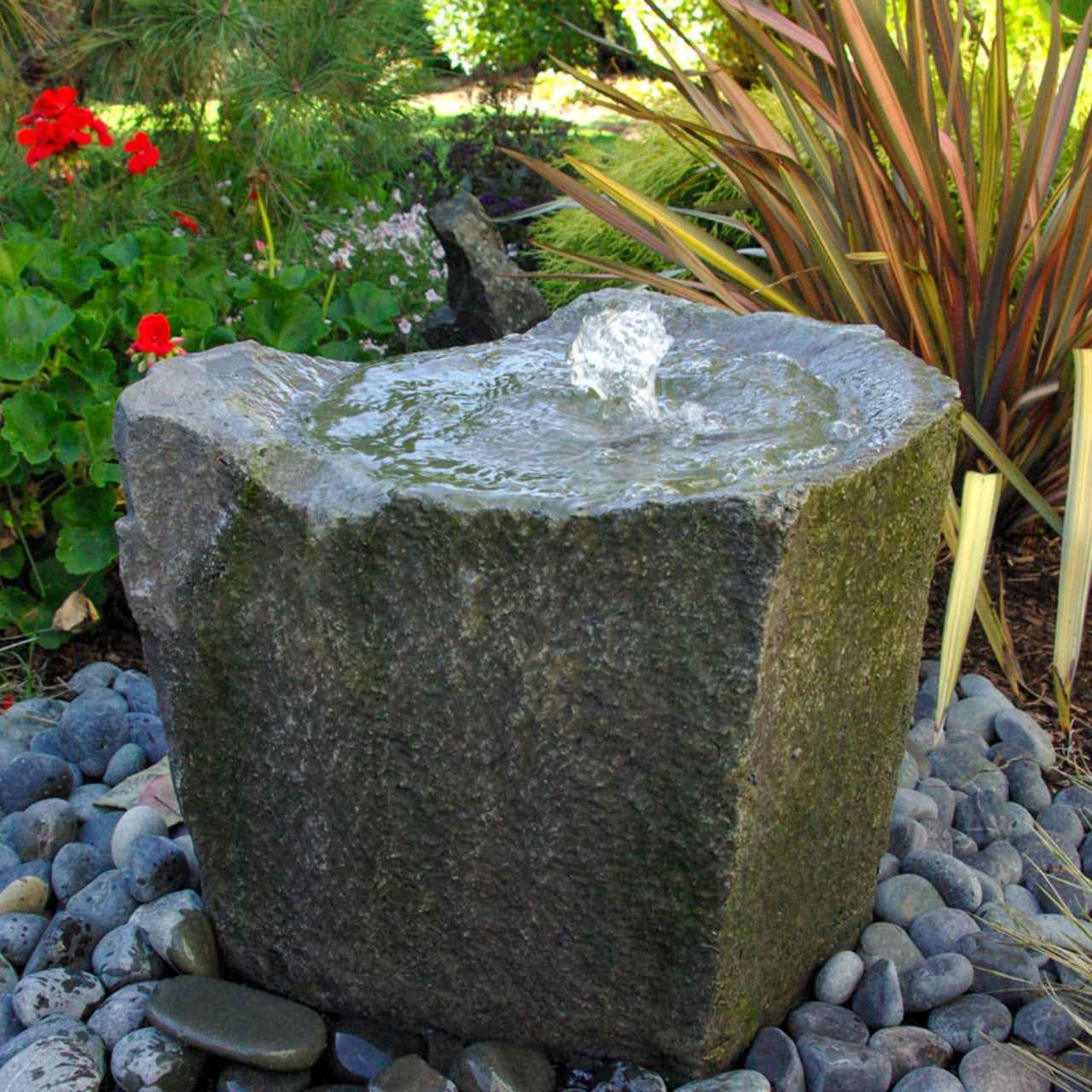 Outdoor Klamath Rock Fountain With Plants And Flowers In The Background