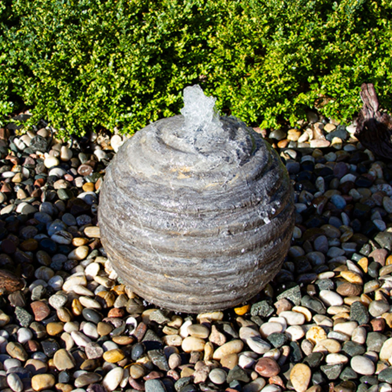 Outdoor Limestone Sphere Fountain With Green Plants Background