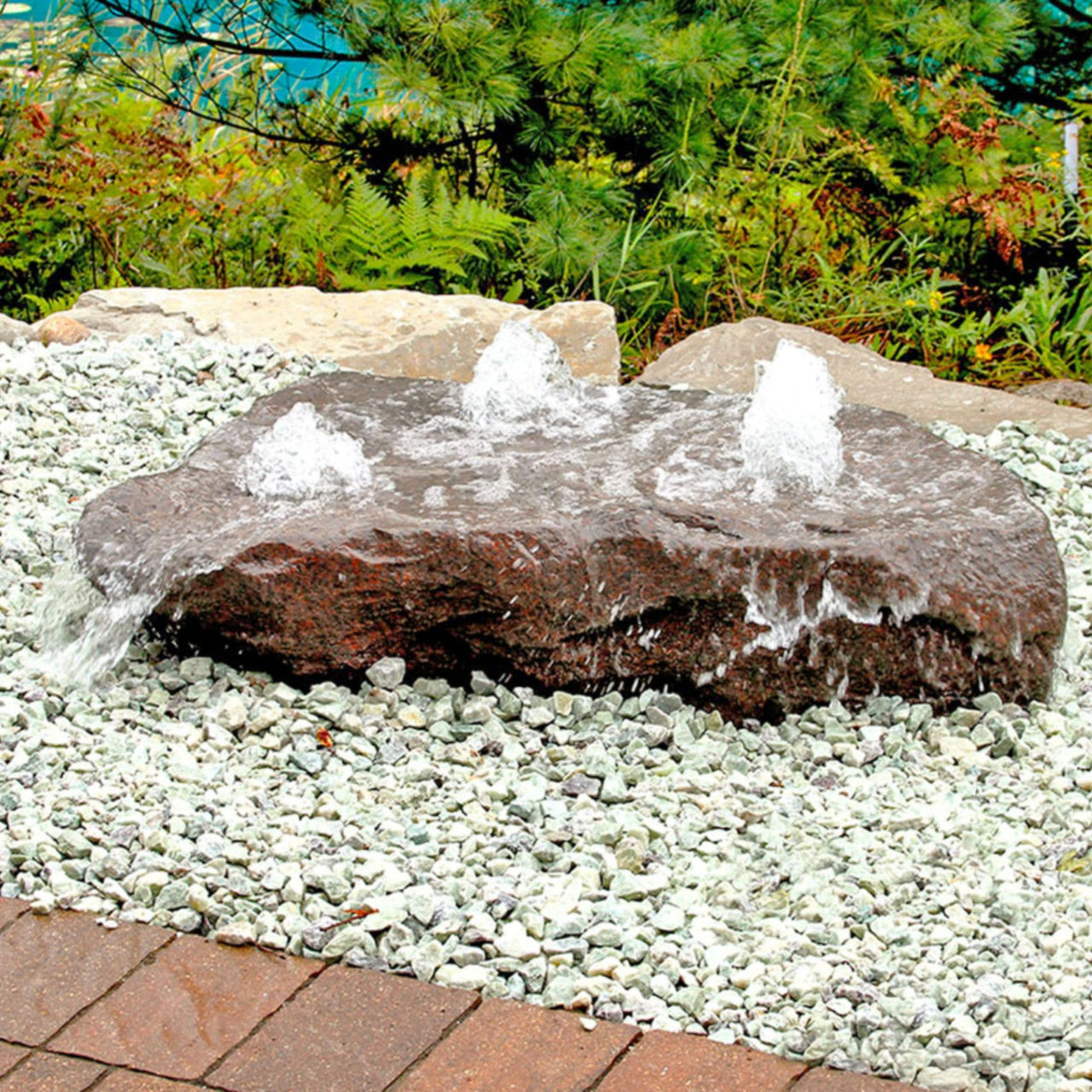 Outdoor Manistique Rock Fountain With Ornamental Grass Behind