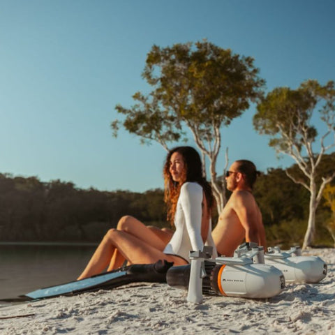 Propulsion Device With A Man and Woman Sitting by the Sea with the Device