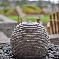 Thumbnail for Ribbed Granite Sphere Stone Fountain On Blurry Background