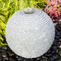 Thumbnail for Ribbed Granite Stone Sphere Fountain With Ferns And Flowers Backdrop