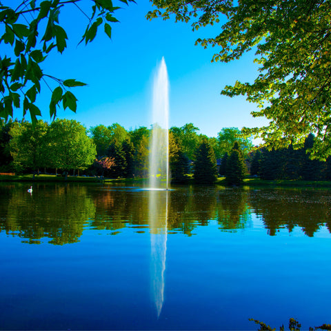 Scott Aerator Gusher Pond Fountain On The Water With Green Trees In The Background
