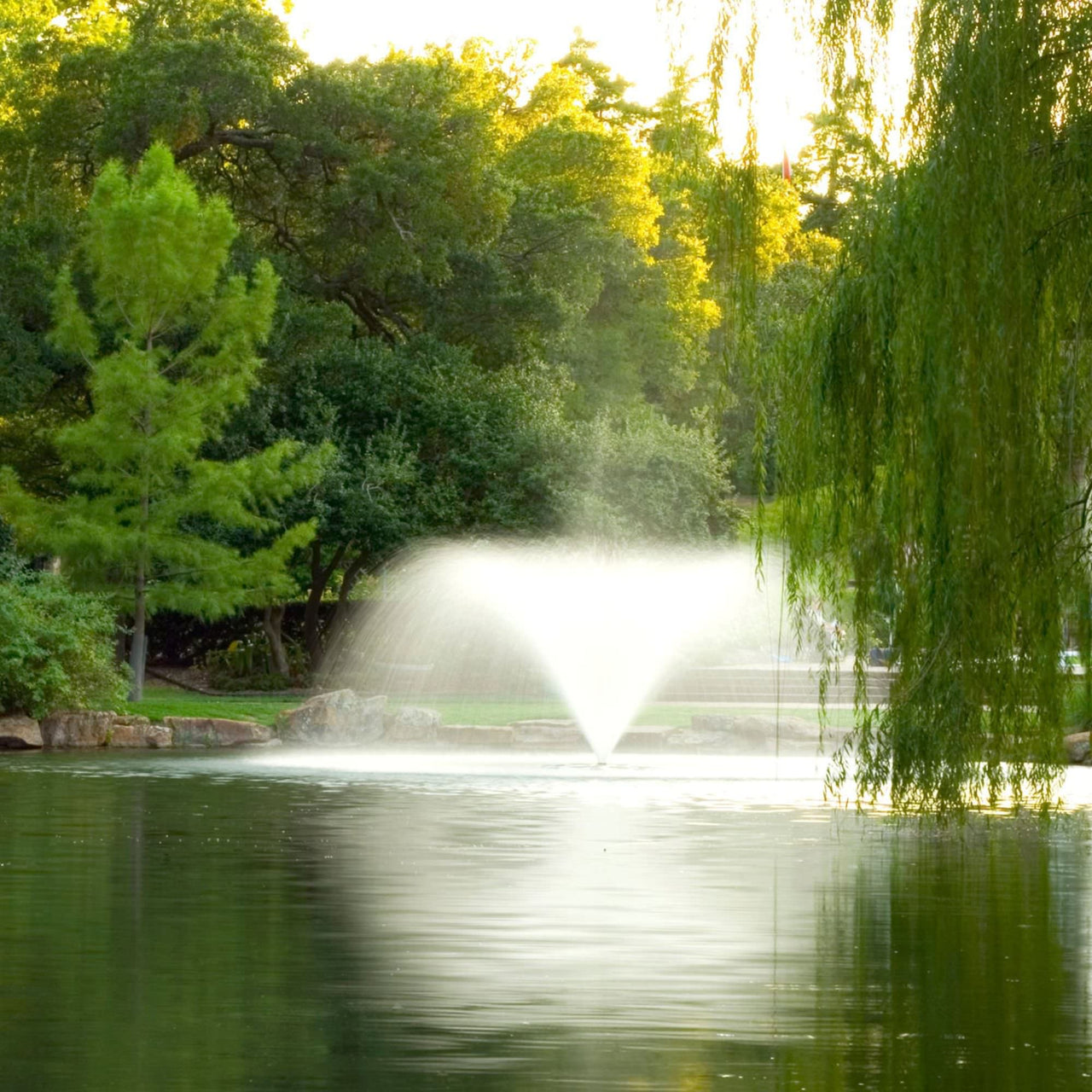 Scott Aerator DA-20 Display Aerator Fountain On Water With Many Green Trees Around