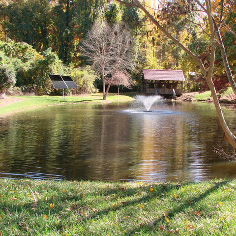 Scott Aerator DA-20 Solar Pond Aerator Fountain On The Water With Trees & A Bridge In The Background