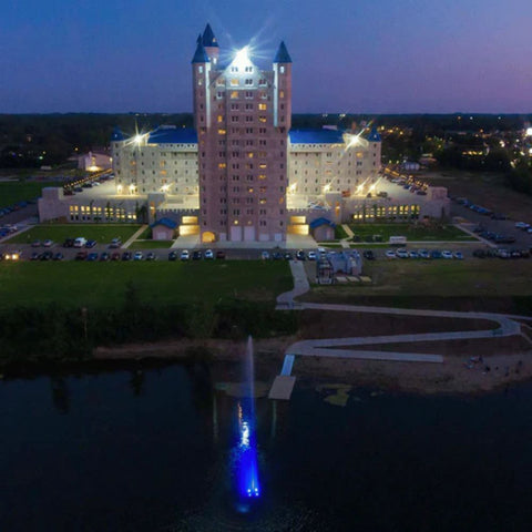 Scott Aerator Jet Stream Pond Fountain With Blue Lights On The Water With A Building In The Background Top View