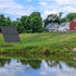 Thumbnail for SolarSeries Direct Drive Aeration System from Airmax Solar Aerator On Farm Near Pond With Two Houses And Trees In The Background