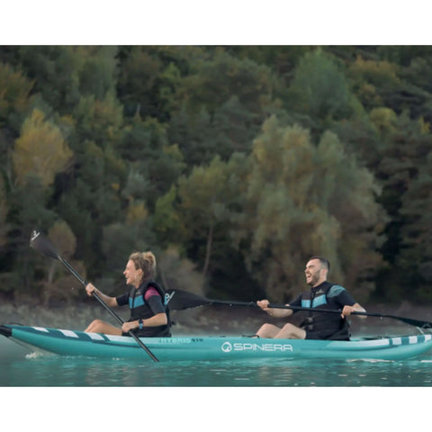 Spinera Hybris 410 Inflatable Kayak With Two People Laughing While Kayaking On Calm Water With Trees Background