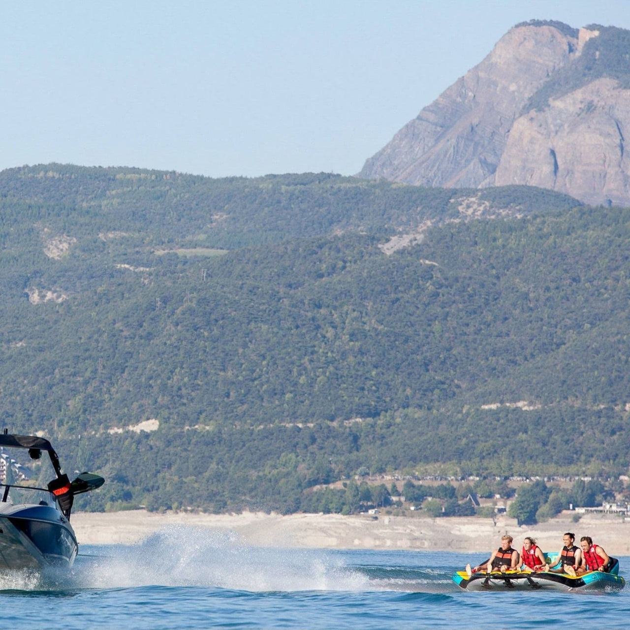 Spinera Just Fun 4 Person Towable With Four People Tubing on Mountain Background