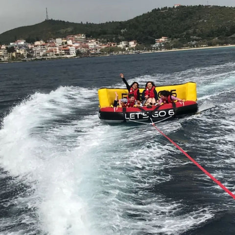 Spinera Lets Go 6 Person Towable Four Riders Enjoying The Ride With Scenic Background