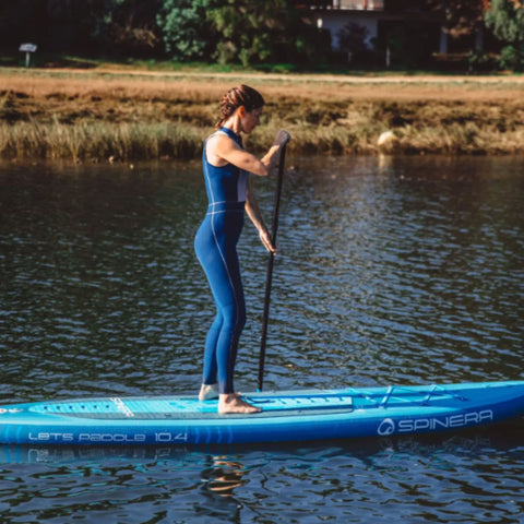 Spinera Lets Paddle 10.4 Paddle Board With a Girl Paddling Through Calm Water
