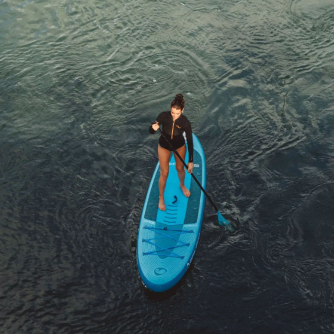 Spinera Lets Paddle 10.4 Paddle Board With a Woman Paddling On Open Water