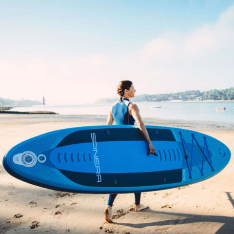 Spinera Lets Paddle 10.4 Paddle Board Woman Carrying the Board Along Beach