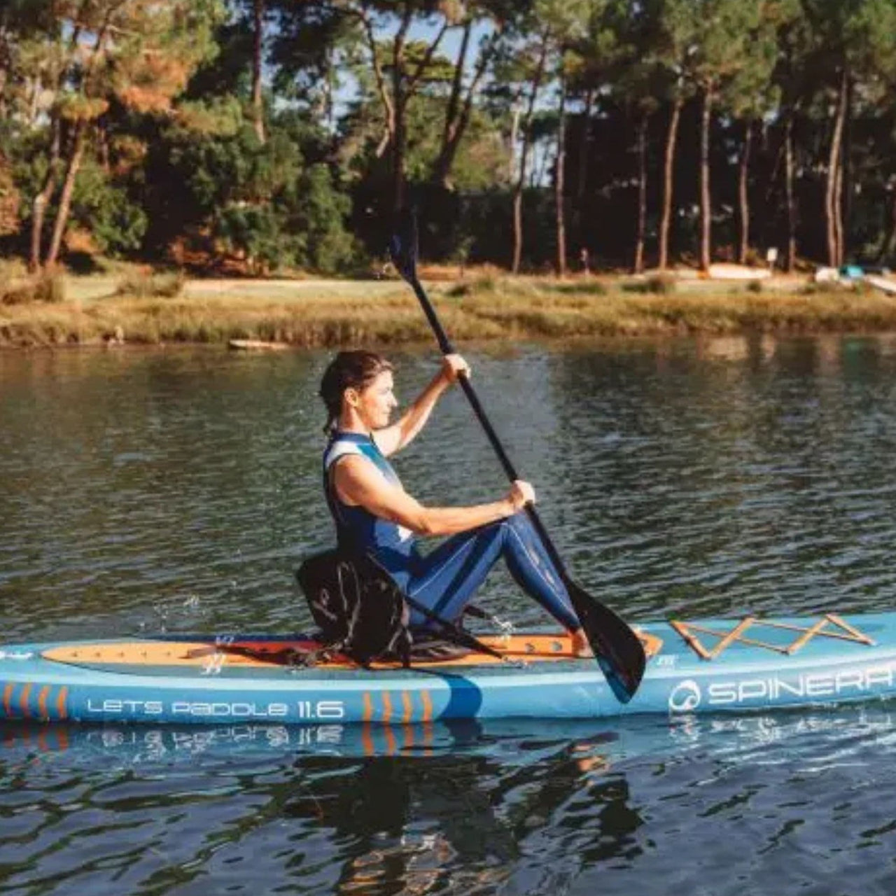 Spinera Lets Paddle 11 6 Paddle Board With A Woman Paddling on Calm Water