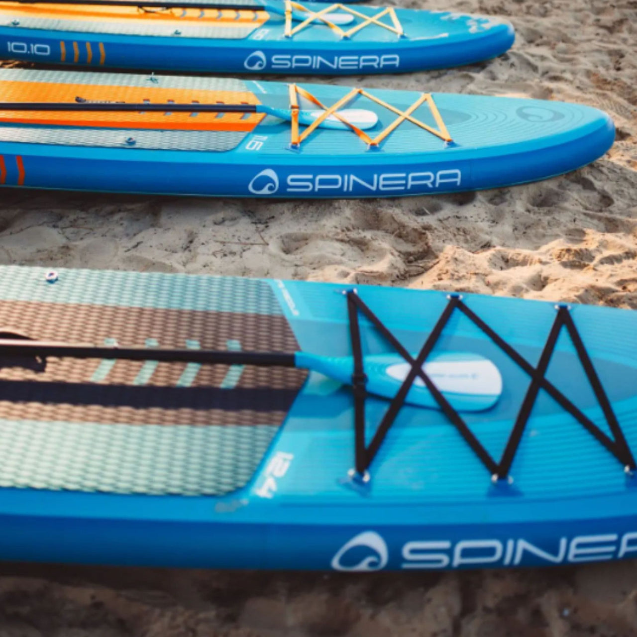 Spinera Lets Paddle 12.4 Paddle Board Lined Up On Sand Shore