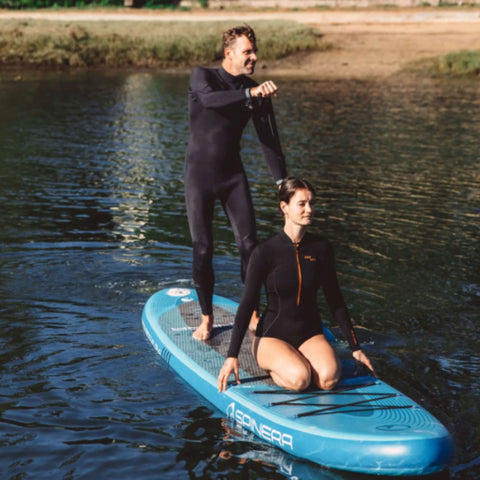 Spinera Lets Paddle 12.4 Paddle Board With a Man Paddling and a Girl Sitting Near Lake Shore