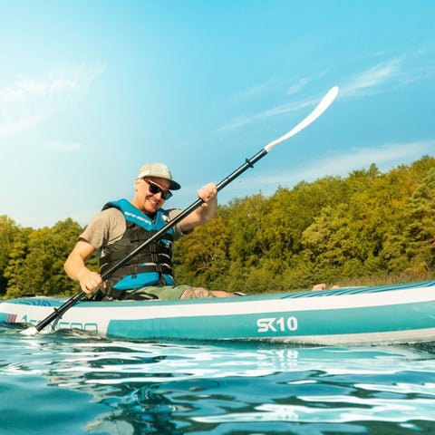 Spinera SK10 With a Man Smiling While Kayaking on Clear Water