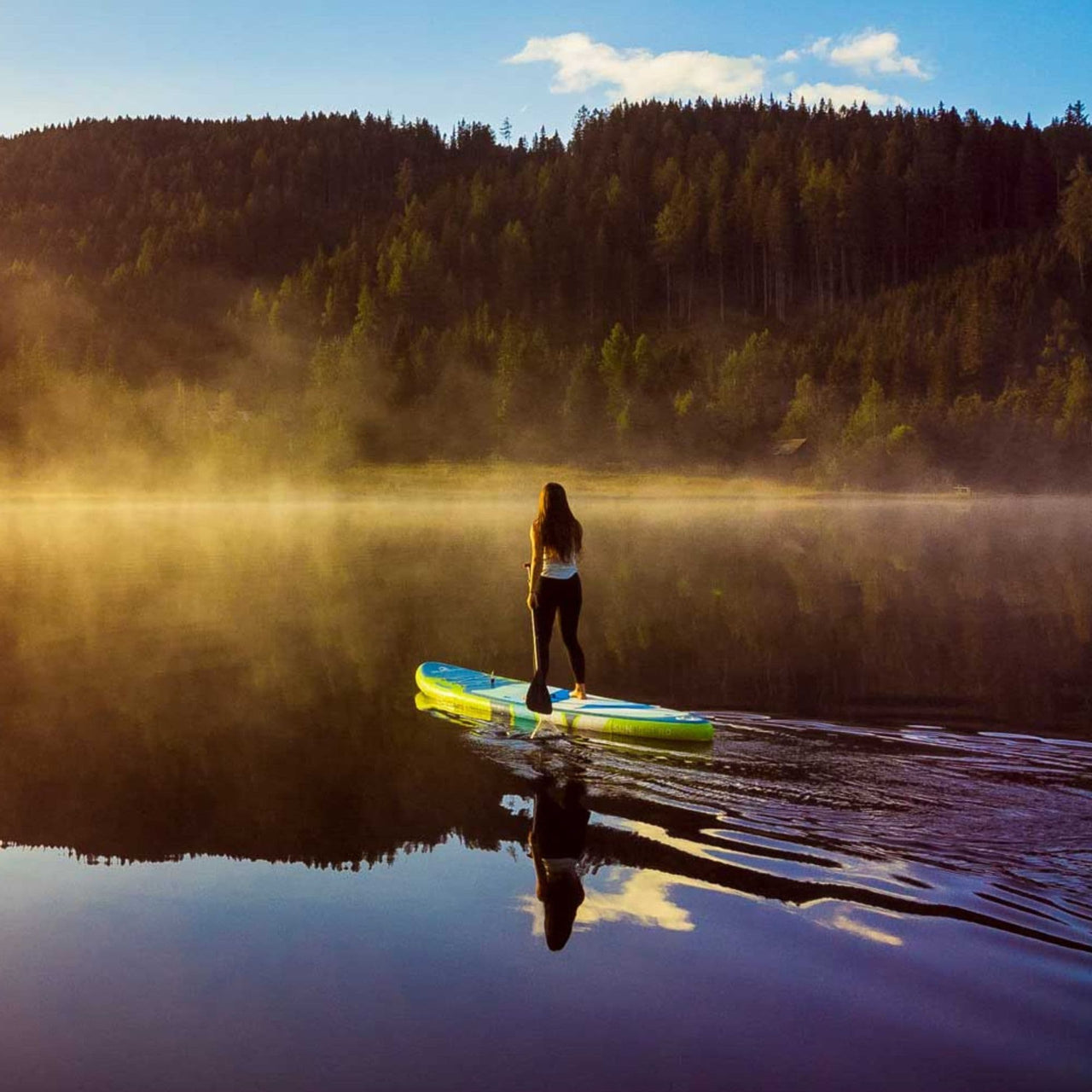 Spinera Sun Light 11.0 Paddle Board With a Woman Gliding on Misty Lake