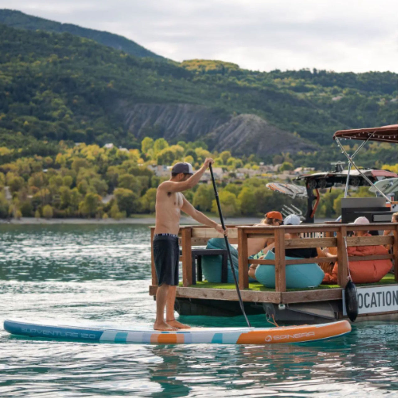 Spinera Supventure Sunrise 12 Paddle Board With a Man Paddling Beside The Boat