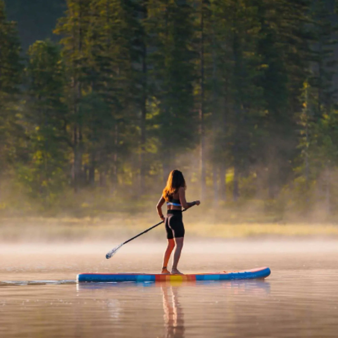 Spinera Supventure Sunset 10.6 Paddle Board With a Woman Paddling on Misty Lake