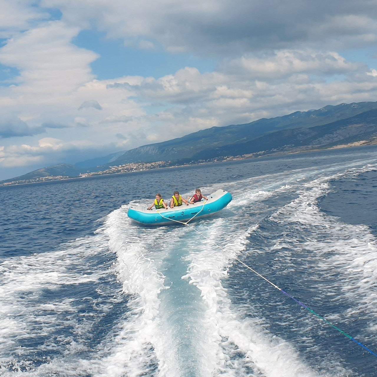 Spinera Wing 5 Towable Tube With Three Kids Enjoying the Waves